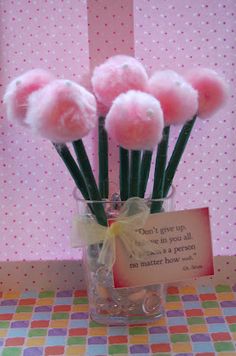 a vase filled with pink pom - poms sitting on top of a table