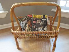 a wicker magazine rack with magazines in it on top of a hard wood floor