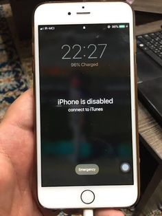 an iphone is disabled connected to a charger in someone's hand