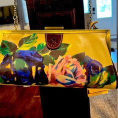 a yellow purse with flowers painted on it