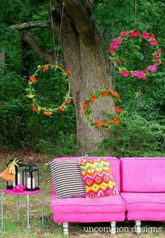 a pink couch sitting in front of a tree