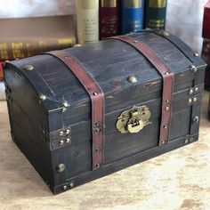 an old trunk is sitting on a table next to some books and other items in the background