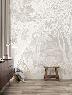 a room with a chair and wallpaper that has trees on it