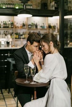 a man and woman sitting at a table with wine glasses