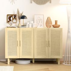 a cabinet with some vases on top of it and a lamp in the corner