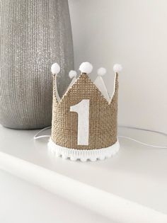 a little crown sitting on top of a white shelf