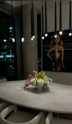 a white table with flowers on it in the middle of a room