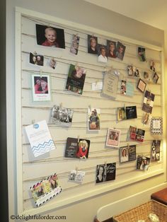 a wall covered in pictures and magnets next to a table