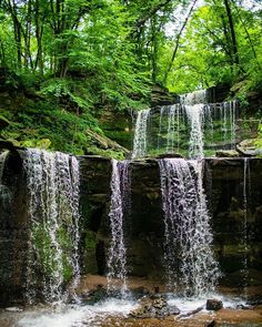 a waterfall in the woods with lots of water