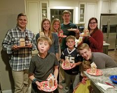 a group of people standing around each other holding plates with cakes on them in front of them