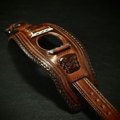 a brown leather belt on a black surface