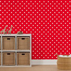 red and white polka dot wallpaper in a living room with wicker baskets on the floor