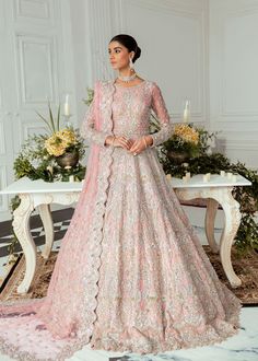 a woman in a pink gown standing on a table