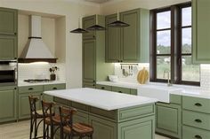 a large kitchen with green cabinets and white counter tops, along with bar stools