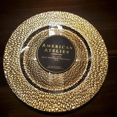 an american atelierr gold plate on a wooden table