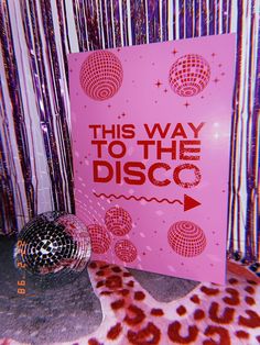 this way to the disco sign is in front of a leopard print wall with red lettering