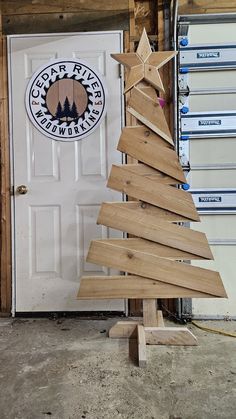 a small wooden christmas tree sitting in front of a door