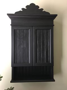 a black cabinet is hanging on the wall