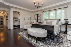 a large bedroom with white walls and wood floors