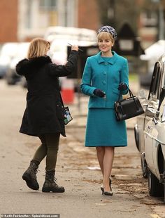 two women are walking down the street and one is holding her hand up in the air