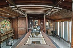 a long wooden table sitting in the middle of a room with stained glass windows on each side