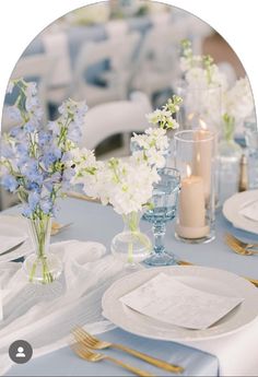 the table is set with white and blue flowers