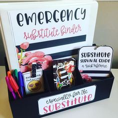 a box filled with assorted items on top of a white table next to a sign