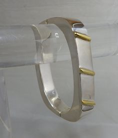 "Here's a stylishly modern hinged bangle bracelet, made in sterling silver and signed with Juan Sandoval Vazquez's Two Trees logo. It has gold vermeil accents on the front in a diagonal pattern, Interior circumference is 6.3/4\" and it is 3/8\" wide. It weighs 42 grams and is fully hallmarked. It is in exceptional pre-owned condition with no scratches or damage. Thanks for looking." Trees Logo, Pattern Interior, Tree Signs, Two Trees, Gold Link Bracelet, Tree Logos, Hinged Bangle, Sign Art, Gold Accents