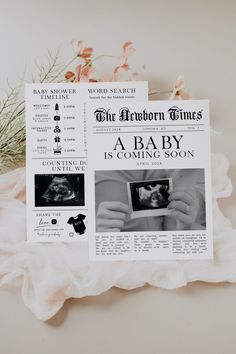 a baby is coming soon newspaper on a white surface with flowers and greenery in the background