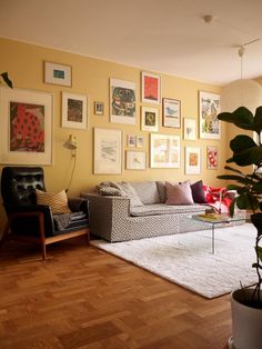 a living room filled with furniture and pictures on the wall