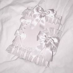 two pink and white baby blankets with bows on top of each other in the shape of a heart