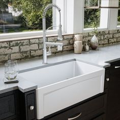 a white kitchen sink sitting under a window