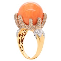 This unusual 18 carat rose gold cocktail ring features an impressive perfectly round natural coral measuring 16.5mm. The wonderful coral is securely held by 8 asymmetrical fluid claws, all masterfully micro set with round brilliant cut diamonds which compliment the coral's natural rich colour. To complete the statement ring 23 round brilliant cut diamonds are inlaid on each shoulder in an 18 carat white gold leaf motif that merges perfectly into the 18 carat yellow gold tapered shank. The diamonds come to a total approximate carat weight of 1.20ct. The overall look of this outstanding piece closely resemble to that of a sceptre. Stamped AP 750. UK finger size 'P'. This beautiful cocktail ring is part of a set that includes a pair of drop earrings and a long station necklace. Rose Gold Cocktail, Yellow Gold Cocktail Ring, Gold Cocktail Ring, Leaf Motif, Gold Cocktail, Natural Coral, Station Necklace, Round Brilliant Cut Diamond, Cocktail Ring