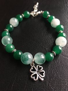 "\"Jade Stone St. Patrick's Day Shamrock Bracelet\" White and green jade stone beads and emerald dyed jade stone beads have been combined with beading detailed silver plated beads. It is closed with a silver toned nickel free lobster clasp and a silver extension chain for added length if needed. This bracelet is adjustable from 7.5 - 8.5-inches and is finished with a silver shamrock charm.  This bracelet would be the perfect St. Patrick's Day gift and would compliment a dressy or casual wardrobe Shamrock Bracelet, Silver Shamrock, Green Bracelet, Sparkly Earrings, Jade Bracelet, Swarovski Crystal Earrings, Jade Stone, Pink Earrings, Green Jade