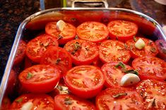 a pan filled with sliced tomatoes on top of a counter