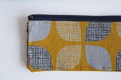 a yellow and gray pouch with circles on it