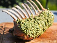 a piece of food that is on top of a cutting board with some kind of green stuff in it