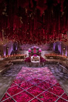 a large room filled with lots of pink flowers and chandeliers hanging from the ceiling