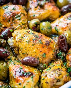 chicken and olives in a pan with seasoning sprinkled on the side