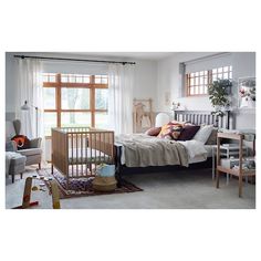 a bed room with a neatly made bed next to a window and a rug on the floor