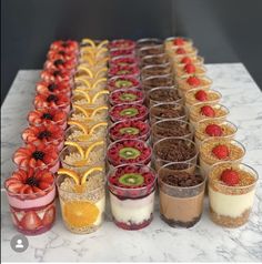 there are many desserts lined up on the table with strawberries and kiwi