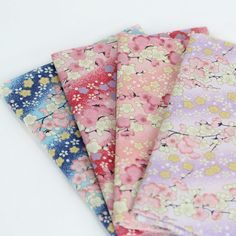 four different colors of fabric with small flowers on the bottom one is pink, blue, yellow and purple