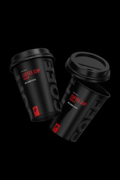 two black coffee cups sitting next to each other on top of a dark background with red lettering