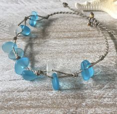 Gorgeous beach bracelet or anklet made with turquoise blue and white sea glass pebbles on our durable hand spun rope cord. Pure island style! Easy and secure adjustable slide knot closure allows for easy on and off. This bracelet/anklet is completely waterproof and metal free making it perfect for anyone with skin sensitivities and is a wonderful and unique gift for those hard to shop for friends and family on your list, especially the beach lovers! Color: Turquoise blue Size: Available in three Beach Glass Bracelets, Cheap Blue Bracelets For Beach, Cheap Blue Beach Bracelets, Handmade Adjustable Coastal Beaded Bracelets, Adjustable Coastal Style Beaded Jewelry, Hand Wrapped Braided Bracelets With Round Beads For Beach, Beach Braided Bracelets With Round Beads, Adjustable Blue Beachy Jewelry, Turquoise Jewelry With Adjustable Cord For Beach