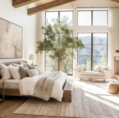 a large bed sitting in a bedroom on top of a hard wood floor next to a window