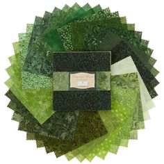 a pile of green and black cloths on top of each other with a label in the middle