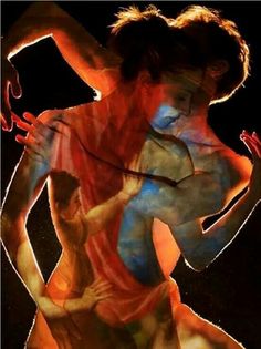 two women are dancing with colored paint on their bodies and hands, one is holding the other's back