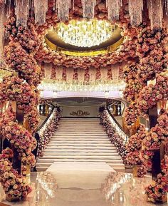 an elaborate staircase decorated with flowers and chandeliers