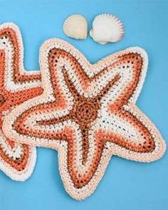 an orange and white beaded starfish next to two cotton balls on a blue background