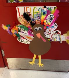 a turkey made out of paper on top of a red door with the words welcome